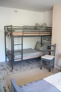 a room with two bunk beds with a chair and a table at Ferienwohnung Arzgebirg in Grünhainichen