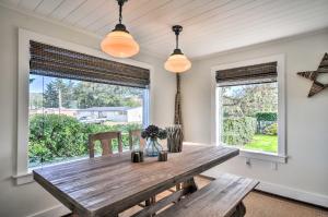 comedor con mesa de madera y 2 ventanas en Waterfront Seaside Beach Home with Views and Hot Tub!, en Seaside