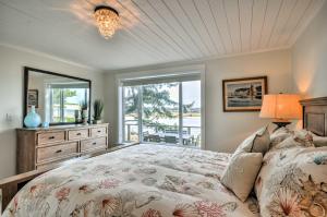 una camera da letto con un letto grande e una finestra di Waterfront Seaside Beach Home with Views and Hot Tub! a Seaside