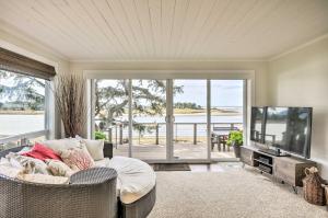 sala de estar con sofá y TV de pantalla plana en Waterfront Seaside Beach Home with Views and Hot Tub!, en Seaside