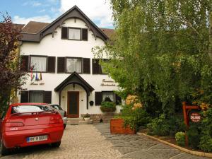 a red car parked in front of a house at Ferienhaus Apartmanház Zalánki in Eger