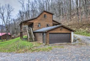 a large wooden house with a garage and a staircase at Rustic Cabin in the Woods 6 Mi to Snowshoe Resort in Slaty Fork