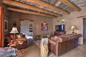 un soggiorno con divano in pelle e una camera con letto di El Prado Adobe Home Courtyard with Mountain Views! a El Prado