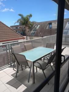 a patio table and chairs on a balcony at Atlas Suites and Apartments in Mount Maunganui