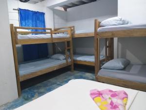 a room with three bunk beds and a bed at Hostel Blue Sea Rincon del Mar in Rincón