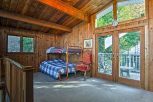 a bedroom with a bunk bed in a wooden house at Lakefront Montague Cottage with Deck and Beach! in Rothbury