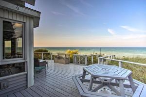 a house with a wooden deck with a view of the ocean at Lakefront Montague Cottage with Deck and Beach! in Rothbury