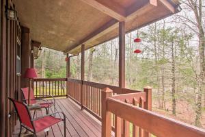 un portico con due sedie e un tavolo sopra di Private Gatlinburg Cabin Pet Friendly with Hot Tub! a Gatlinburg