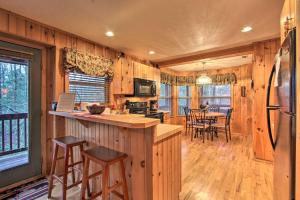 una cucina e un soggiorno con tavolo e sedie di Private Gatlinburg Cabin Pet Friendly with Hot Tub! a Gatlinburg