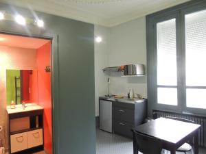 a small kitchen with a table and a sink at Appartement Le Gambetta in Le Mans