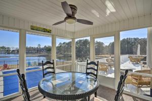 un porche cubierto con mesa y sillas en Carolina Lakes Family Home with Pool, Kayaks and Dock!, en Johnsonville