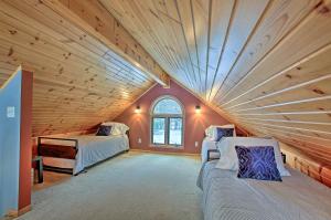 a attic room with two beds and a large window at Waterfront Fife Lake Cottage Dock, Kayak, Sunroom in Fife Lake