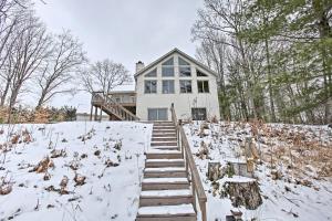 a white house with stairs in the snow at Waterfront Fife Lake Cottage Dock, Kayak, Sunroom in Fife Lake