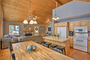 cocina y sala de estar con techo de madera en Cozy Waterfront Fife Lake Cottage with Dock and Kayaks! en Fife Lake