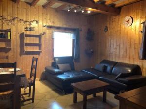 a living room with a leather couch and a table at Chalet Baptiste in Orcières