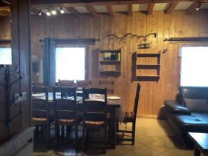 a dining room with a table and chairs and a couch at Chalet Baptiste in Orcières