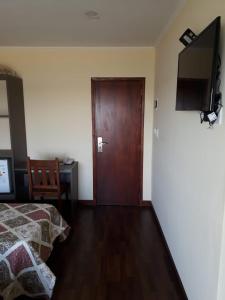 Un dormitorio con una cama y una puerta de madera. en Hotel Dos Mares, en Balneario Mar Chiquita