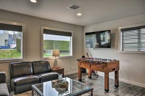 a living room with a foosball table and a couch at Sleek Riverfront Condo on Pier in Downtown Astoria in Astoria, Oregon