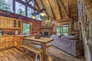 a kitchen and living room in a log cabin at Remote Cabin on 30 Acres with Dock and Private Lake! in Macks Creek