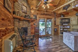 a living room with a fireplace in a log cabin at Remote Cabin on 30 Acres with Dock and Private Lake! in Macks Creek