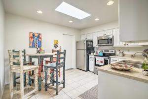 a kitchen with white cabinets and a table and chairs at Mountain-View Albuquerque Townhome with Patio! in Albuquerque