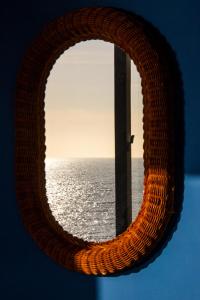 a circular mirror with a view of the ocean at Dimore Santojanni - La Casa sul Porto in Maratea