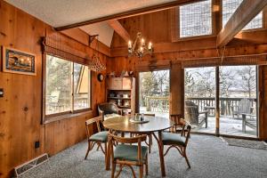 comedor con mesa, sillas y ventanas en Lakeview 10-Acre Kimball Cabin with Private Beach!, en Kimball