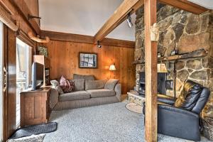 sala de estar con sofá y pared de piedra en Lakeview 10-Acre Kimball Cabin with Private Beach!, en Kimball