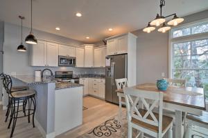 a kitchen with white cabinets and a table and chairs at Lakefront Cadillac Home with Dock, Fire Pit and Grill! in Cadillac