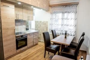 a kitchen and dining room with a table and chairs at Vujisić Apartment in the City Center in Kolašin