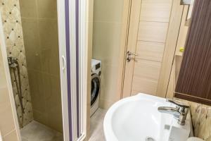 a bathroom with a sink and a washing machine at Vujisić Apartment in the City Center in Kolašin