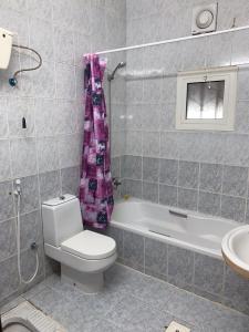 Un baño con inodoro, bañera y lavabo. en Masaken alkenan, en Yanbu 61 fotos más