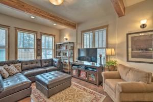 a living room with couches and a flat screen tv at Updated Townhome with Hot Tub - Walk to Downtown! in Red Lodge