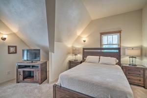 a bedroom with a bed and a tv and a window at Updated Townhome with Hot Tub - Walk to Downtown! in Red Lodge
