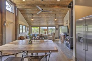 a kitchen and living room with a large wooden table at Updated Cabin with Hot Tub about 11 Mi to Winter Park! in Tabernash