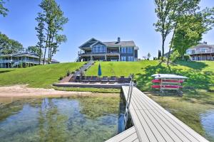 a house on top of a hill with a body of water at Sunroom and Hot Tub! Waterfront Silver Lake Home in Traverse City