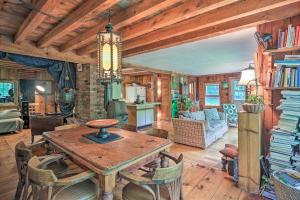 a kitchen and living room with a table and chairs at The Mill River Cabin with Fireplace and River View! in Mill River