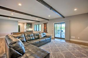 a living room with a leather couch and a kitchen at Waterfront Silver Lake Home with Private 40 Dock! in Traverse City