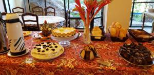 a table with cakes and other desserts on it at Ilha da Galé Tourist Hotel Fazenda de Bombas in Bombinhas
