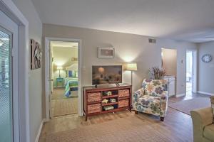 a living room with a tv and a chair at Amelia Island Condo with Onsite Pool and Beach Access! in Amelia Island