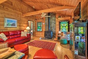 a living room with a red couch and a fireplace at Lakefront Milledgeville Cabin Private Dock, Porch in Resseaus Crossroads