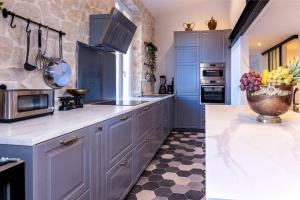 - une cuisine avec des armoires bleues et un bol de fruits sur le comptoir dans l'établissement PENTHOUSE Loft 5MIN PALAIS DES FESTIVALS AND BEACH terrace view on castle, à Cannes
