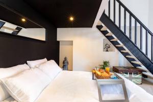 a bedroom with a white bed and a staircase at PENTHOUSE Loft 5MIN PALAIS DES FESTIVALS AND BEACH terrace view on castle in Cannes