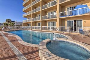 a swimming pool in front of a building at Resort Pool, Gym & Hot Tub: Beachfront PCB Condo! in Panama City Beach
