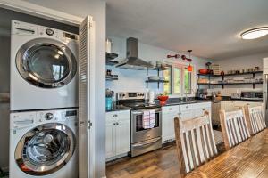 a kitchen with a washer and dryer next to a table at Waterfront Charlevoix Home with Kayaks and Fire Pit! in Ellsworth