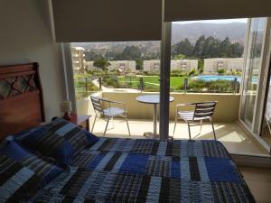 a bedroom with a bed and a view of a patio at Lomas Papudo 4 in Papudo