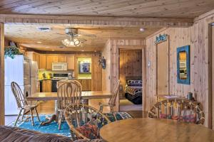 una cucina con pareti in legno, tavoli e sedie in legno di Lakefront Escape with Fishing Pier and Snowmobiling! a Park Falls