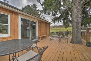 a deck with a table and chairs and a tree at Vintage Farmhouse about 2 half Mi to Mount Pleasant Ski in Cambridge Springs