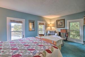 a bedroom with a bed and a chair and windows at Vintage Farmhouse about 2 half Mi to Mount Pleasant Ski in Cambridge Springs