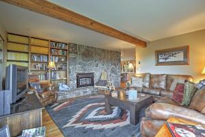 sala de estar con muebles de cuero y pared de piedra. en Private Steamboat Springs Home with Hot Tub and Mtn Views, en Steamboat Springs